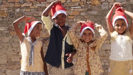 Grupo-de-jóvenes-amigos-aplaudir-y-luego-tire-hacia-arriba-de-sus-sombreros-de-Santa-sonriendo