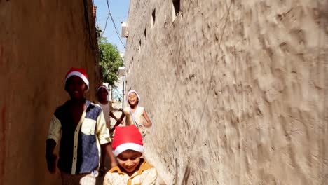 Group-of-young-friends-with-Santa-hats-running-towards-the-camera-and-making-funny-faces