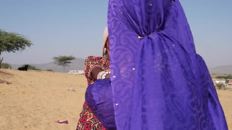 Mujer-nómada-bailando-delante-de-camellos-en-Pushkar-Mela-festival,-India