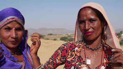 Cerca-de-dos-amigos-de-India-las-mujeres-charlando-con-otros-en-el-sol-al-aire-libre-en-verano