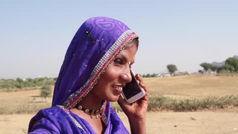 Primer-plano-de-una-mujer-en-ropas-tradicionales-y-la-joyería-hablando-por-su-teléfono