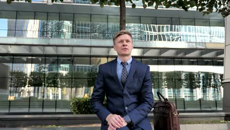 Businessman-in-Suit-Sitting-Outside-Office