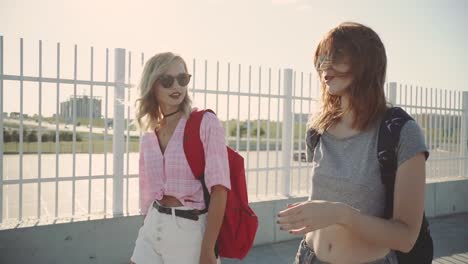 Two-young-attractive-women-talking-and-walking-on-street