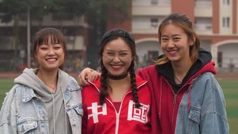 Three-happy-asian-college-girl-smile-at-camera