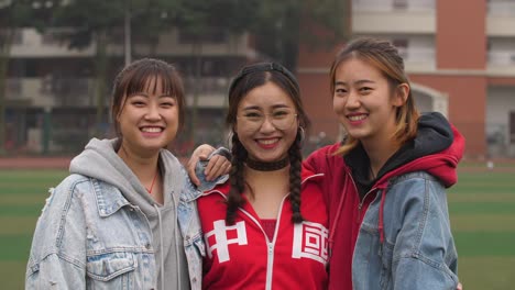 Three-happy-asian-college-girl-smile-at-camera