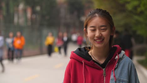 Portrait-of-young-asian-girl-smile-at-camera-in-campus