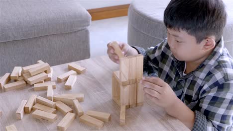 Asiatische-Kinder-junge-spielt-mit-Holzklötzen-Spiel-zu-Hause.