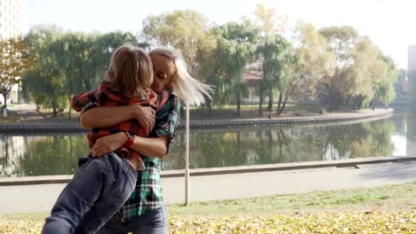 Junge-Mutter,-die-Spaß-mit-ihrem-Sohn-im-Herbst-Park-am-sonnigen-Tag