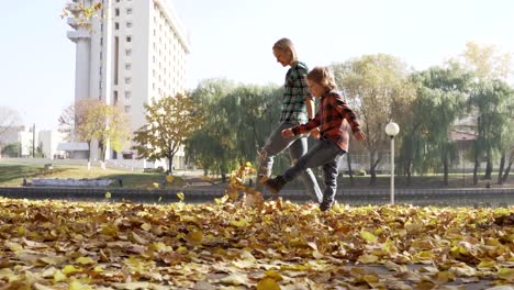 Junge-Mutter,-die-Spaß-mit-ihrem-Sohn-im-Herbst-Park-am-sonnigen-Tag