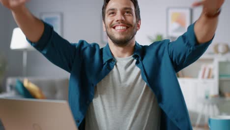 Handsome-Happy-Man-Does-Funny-Dance-Routine-while-Sitting-at-His-Desk-in-the-Living-Room.