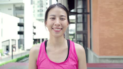 Gesunde-schöne-junge-asiatische-Läufer-Frau-glücklich-lächelnd-und-betreuen,-Kamera-läuft-auf-Straße-in-der-Stadt.-Lebensstil-und-aktive-Frauen-trainieren-in-der-City-Konzept.