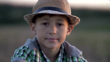 portrait-of-a-happy-village-boy-looking-at-the-camera-and-turning,-outdoors