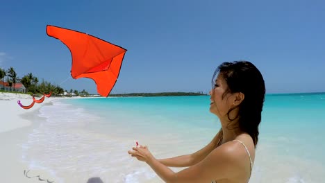 Asiatische-chinesische-Mädchen-am-Strand-spielen-mit-kite