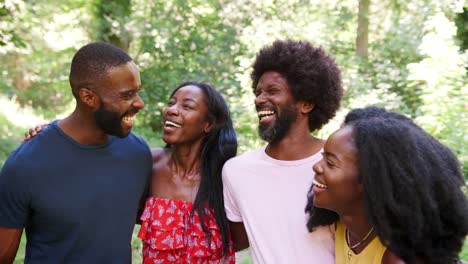 Four-black-adult-friends-on-a-walk-in-the-forest-embracing