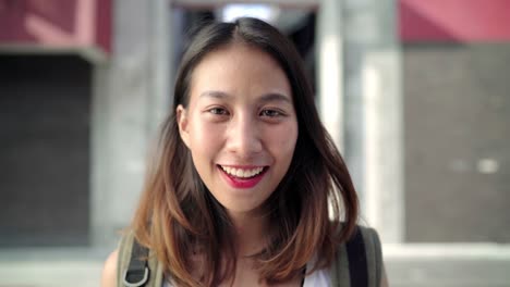 Cheerful-beautiful-young-Asian-backpacker-woman-feeling-happy-smiling-to-camera-while-traveling-at-Chinatown-in-Beijing,-China.-Lifestyle-backpack-tourist-travel-holiday-concept.