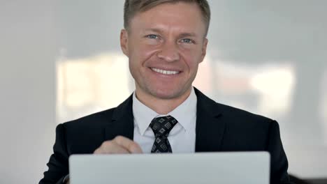 Thumbs-Up-by-Businessman-Looking-at-Camera