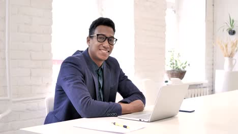 Thumbs-Up-by-Businessman-at-Work-Looking-at-Camera