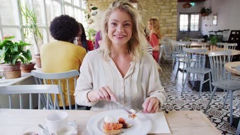 Adulto-joven-comer-brunch,-reaccionar-y-hablar-a-la-cámara-en-un-restaurante,-dispararon-desde-el-POV-de-acompañante