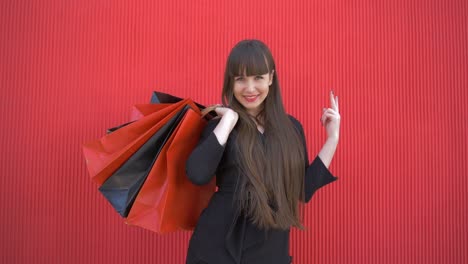 shopping-time,-happy-young-woman-with-red-lips-blows-long-kiss-to-the-camera-with-paper-bags-in-hands