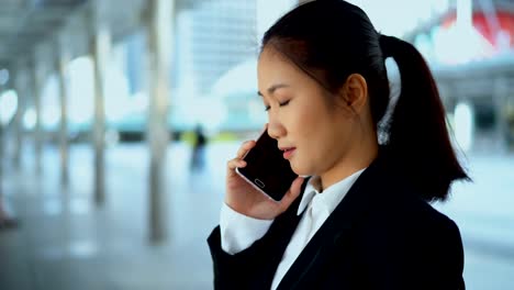 Pretty-business-woman-talking-with-smartphone-at-outdoor-the-office