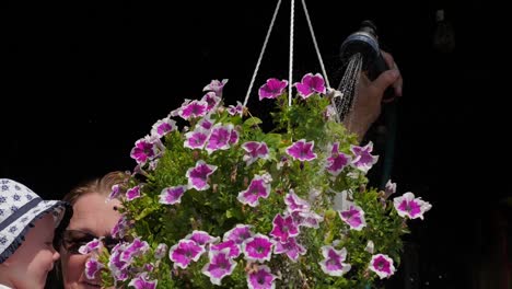 Baby-girl-with-grandmother-watering-flowers.