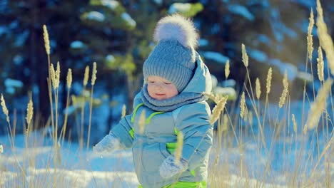 Glückliches-Baby-im-Schnee-stehen-und-lachen.-Schaut-sich-um.-Wintertag.-Close-up