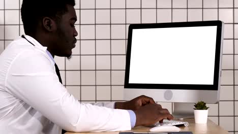 Mature-doctor-working-on-computer.-White-Display