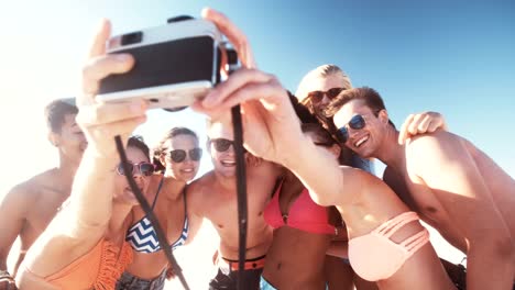 Group-of-friends-taking-a-group-selfie-on-a-beach