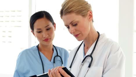 Doctors-looking-over-a-file-and-looking-at-camera