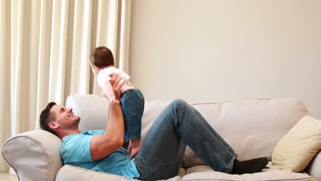 Vater-spielt-mit-seinem-kleinen-Jungen-auf-der-couch