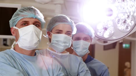 Surgical-team-looking-at-the-camera-in-operating-theater