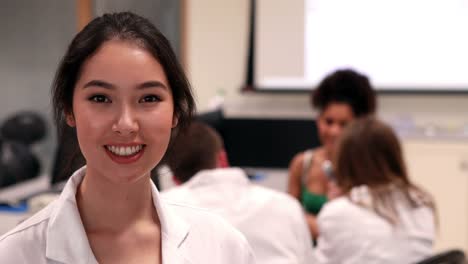 Pretty-estudiante-de-medicina-sonriendo-a-la-cámara-en-clase