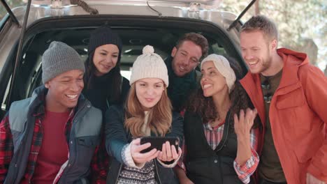 Amigos-tomando-un-selfie-en-el-portón-abierto-de-un-coche