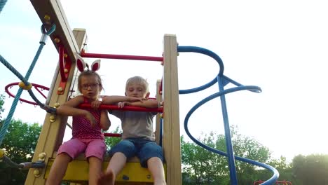 Girl-with-ears-and-glasses-and-boy-with-white-hair-having-fun-on-the-children's-tower.