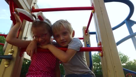 Girl-with-ears-and-glasses-and-boy-with-white-hair-having-fun-on-the-children's-tower.