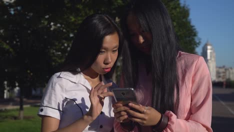 Two-female-holding-cell-chatting-smiling