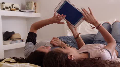 Teenage-girls-lying-on-bed-take-selfie-with-tablet-computer,-shot-on-R3D