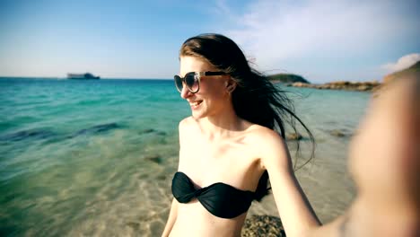 Hermosa-mujer-tomando-selfie-usando-el-teléfono-en-la-playa-sonriendo-y-disfrutando-de-estilo-de-vida-de-viaje-en-vacaciones