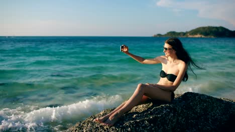 Hermosa-mujer-tomando-selfie-usando-el-teléfono-en-la-playa-sonriendo-y-disfrutando-de-estilo-de-vida-de-viaje-en-vacaciones