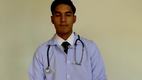 Handsome-confident-medical-doctor-with-a-stethoscope-around-his-neck-is-looking-at-camera-while-standing-over-white-background