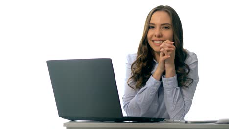 Sonriente-joven-empresaria-sentado-en-una-mesa-de-oficina-con-ordenador-portátil