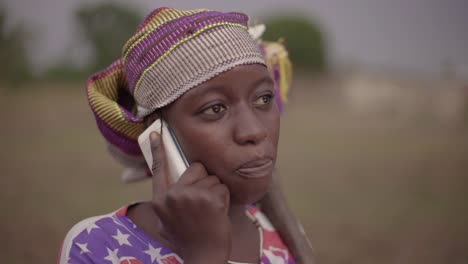 Retrato-de-una-joven-agricultora-africana-hablando-espontáneamente-por-su-teléfono-celular