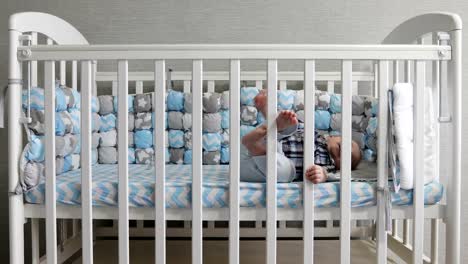 The-happy-kid-lies-in-a-baby-crib.