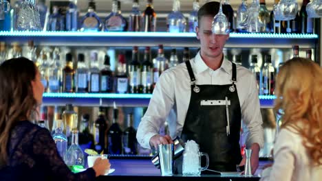 Bartender-is-making-cocktail-at-bar-counter-for-two-girl