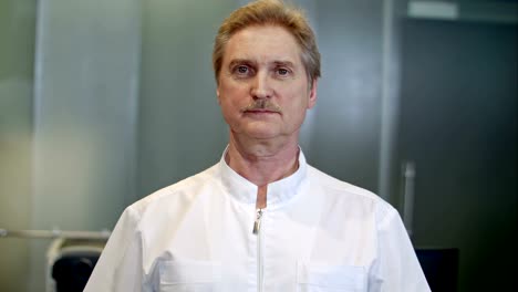 Portrait-of-a-confident-senior-doctor-standing-at-hospital-while-looking-at-camera