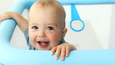 Baby-boy-smiling-at-camera-while-standing-manege