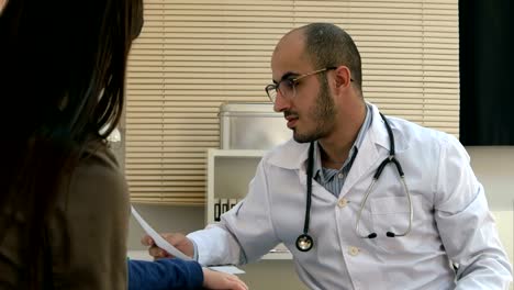 Young-doctor-in-glasses-explaining-diagnosis-to-mother-and-her-child