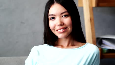 Cheerful-young-woman-smiling-at-home