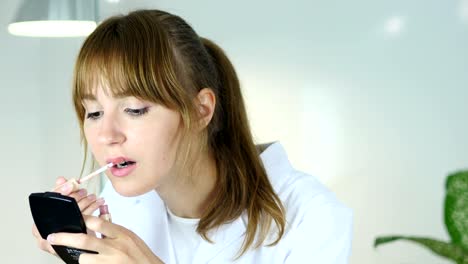 Retrato-de-hermosa-niña-poniendo-Lipstock-en-los-labios