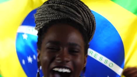 Joven-brasileño-negro-a-mujer-celebrando-con-la-bandera-de-Brasil